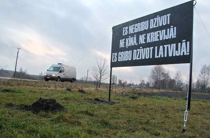 Ar lielformāta plakātu šosejas malā vēršas pret uzturēšanās atļauju tirgošanu