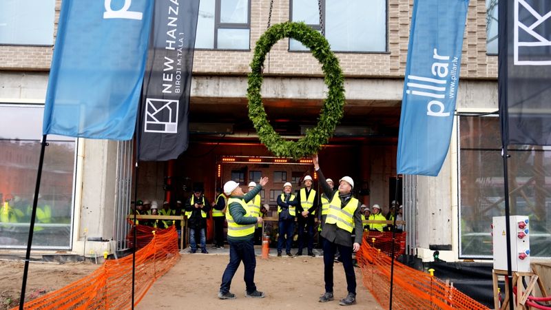 FOTO: New Hanza teritorijas pirmajai biroju ēkai nosvinēti spāru svētki